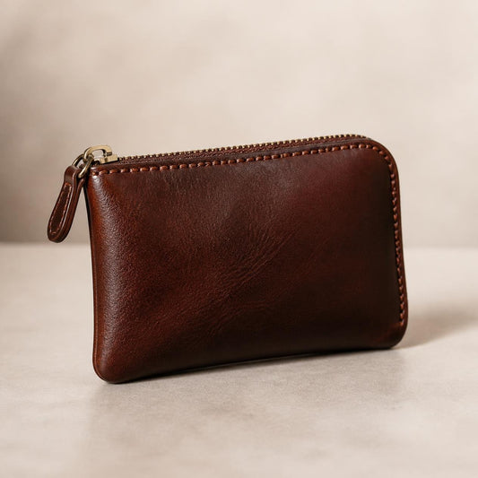 Brown leather coin pouch with top zipper, leather zipper pull and stitched edges