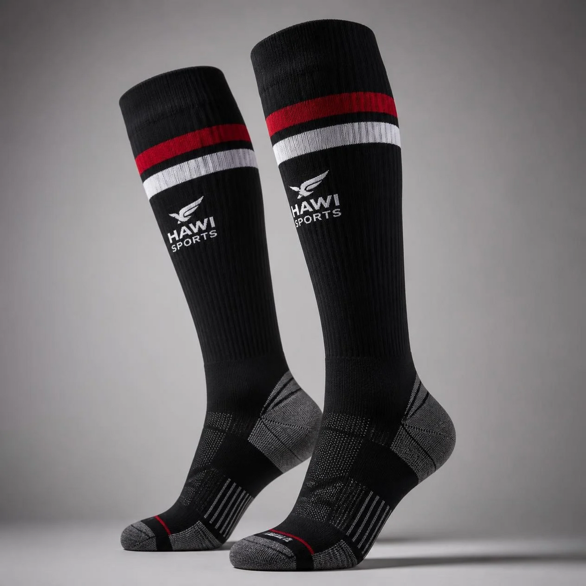 Pair of black Hawi Sports rugby socks with red and white stripes and gray heels